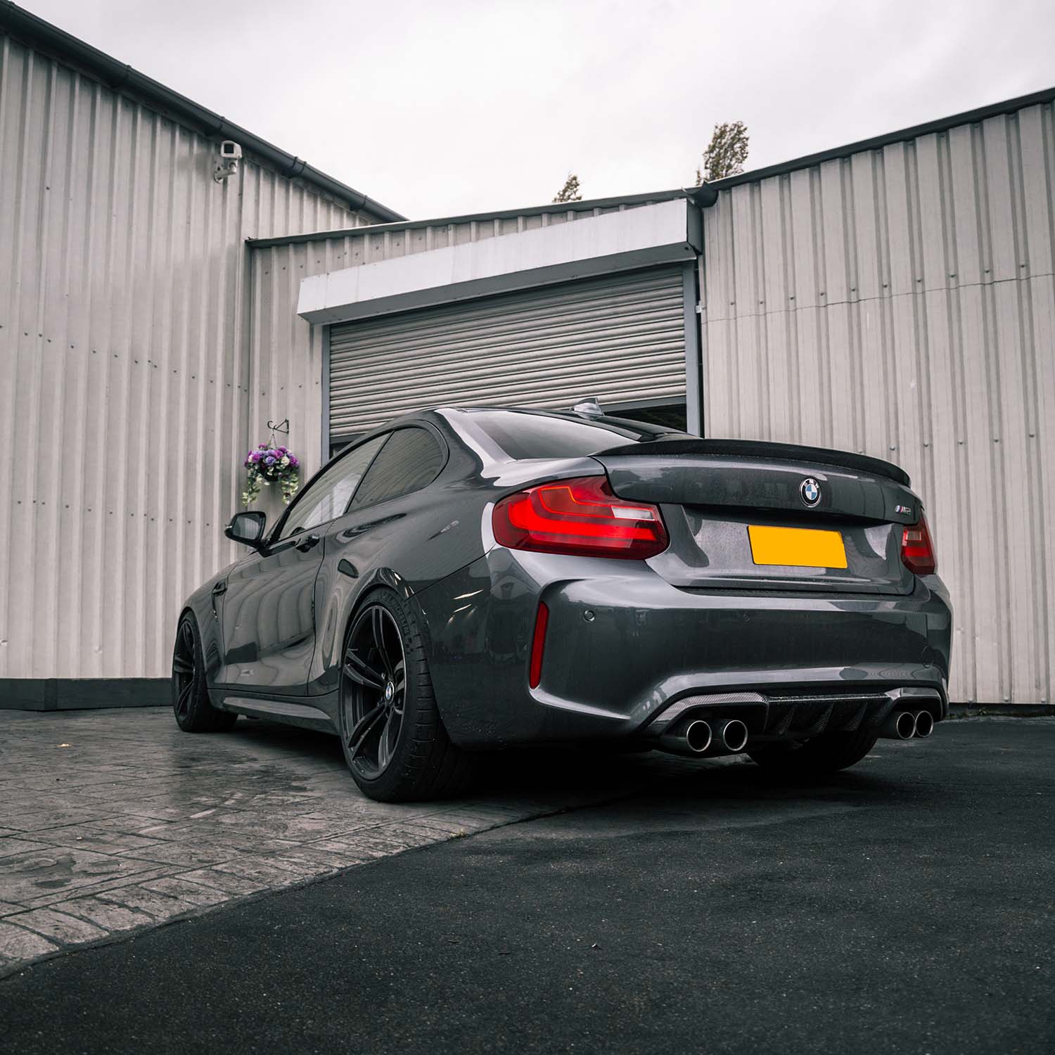 MHC+ BMW F87 M2 Gloss Carbon Fibre Performance Rear Diffuser Fitted On Grey Car Rear Quarter