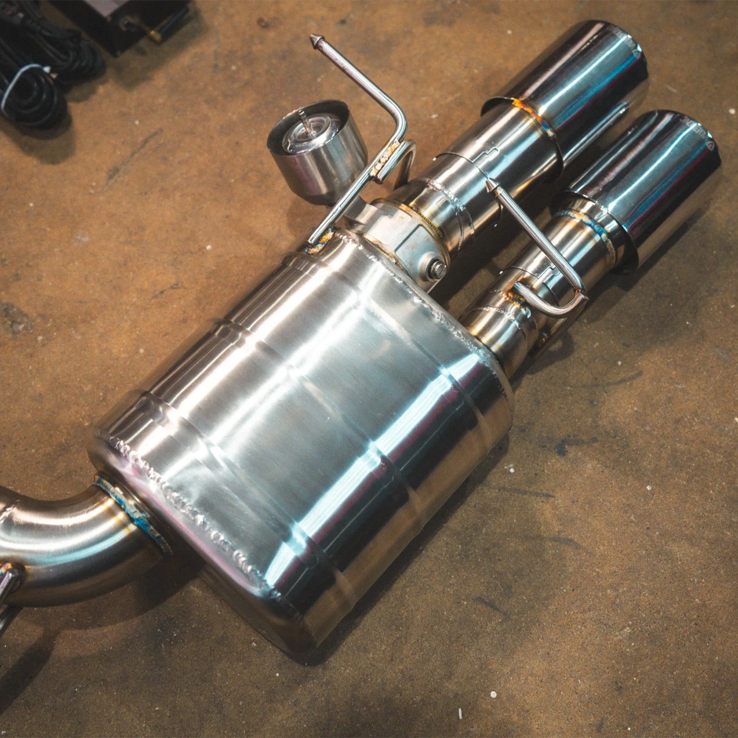 BMW E60 M5 Valvetronic Designs exhaust system on a concrete floor